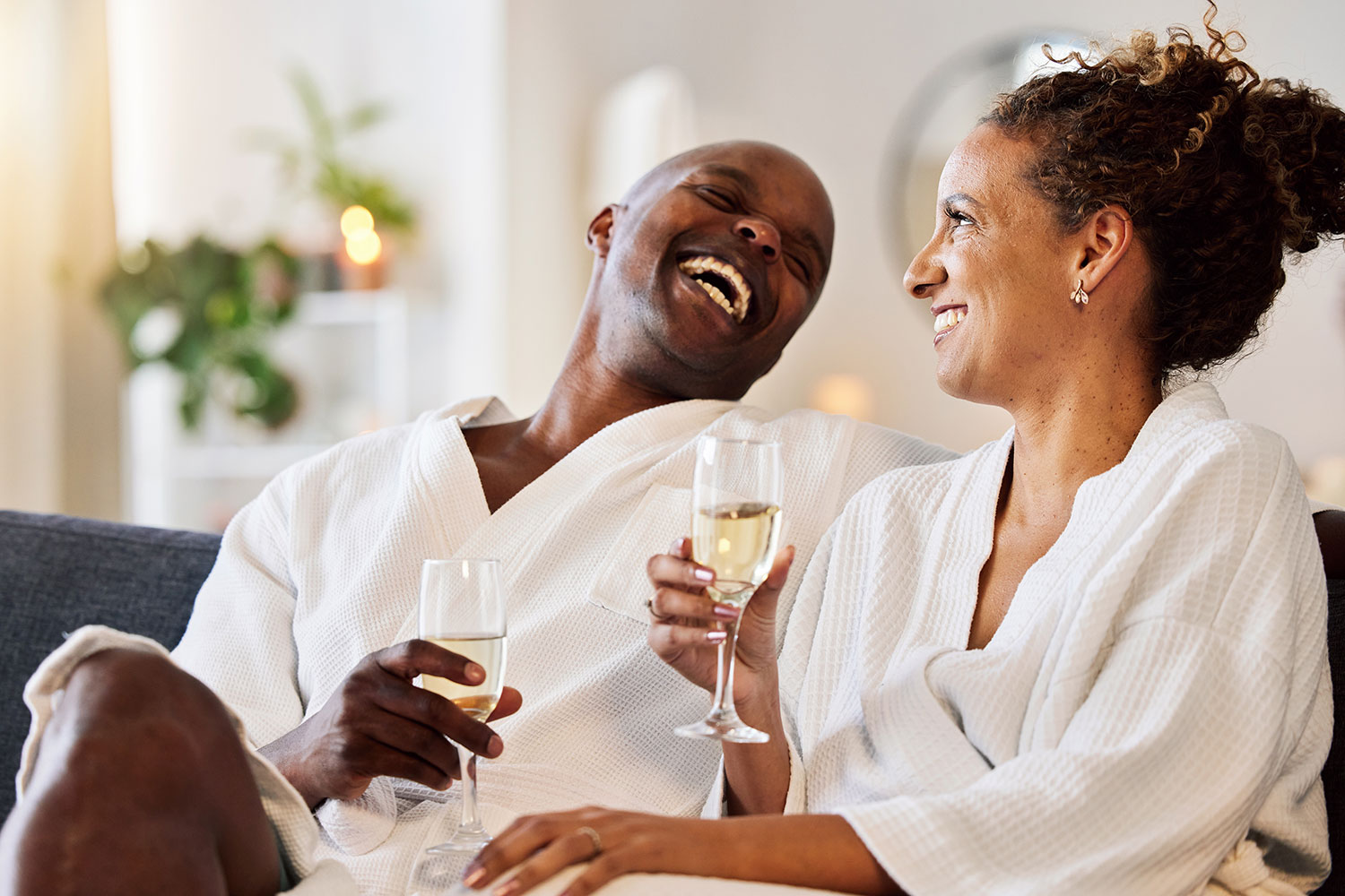 A couple laughing with a glass of champagne
