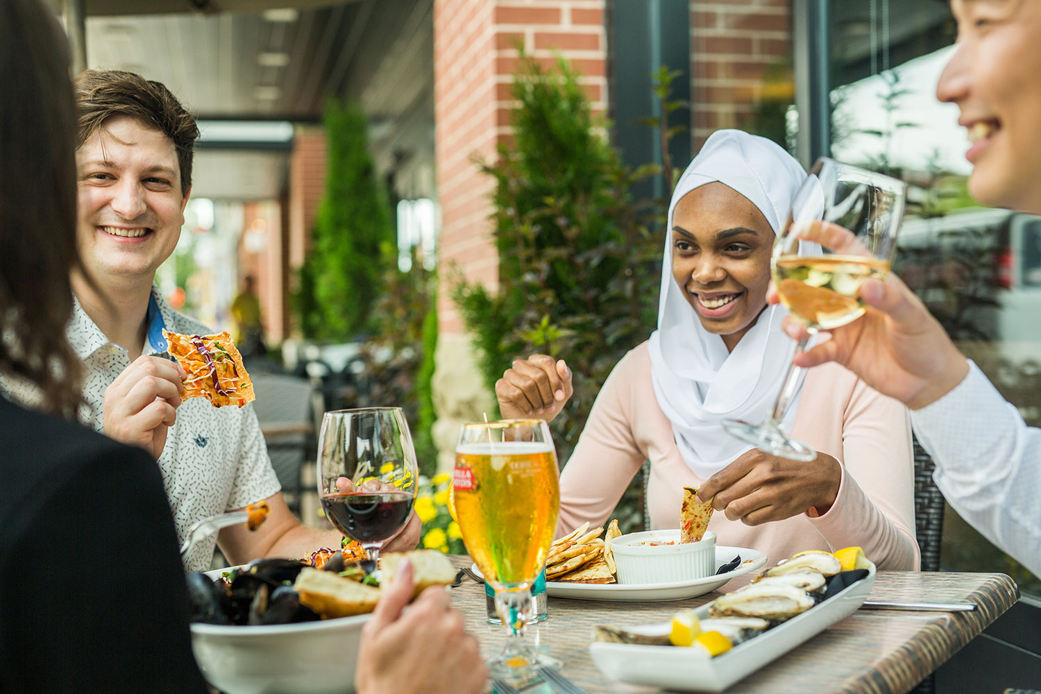 A group of friends dining at the Redwater Rustic Grille patio